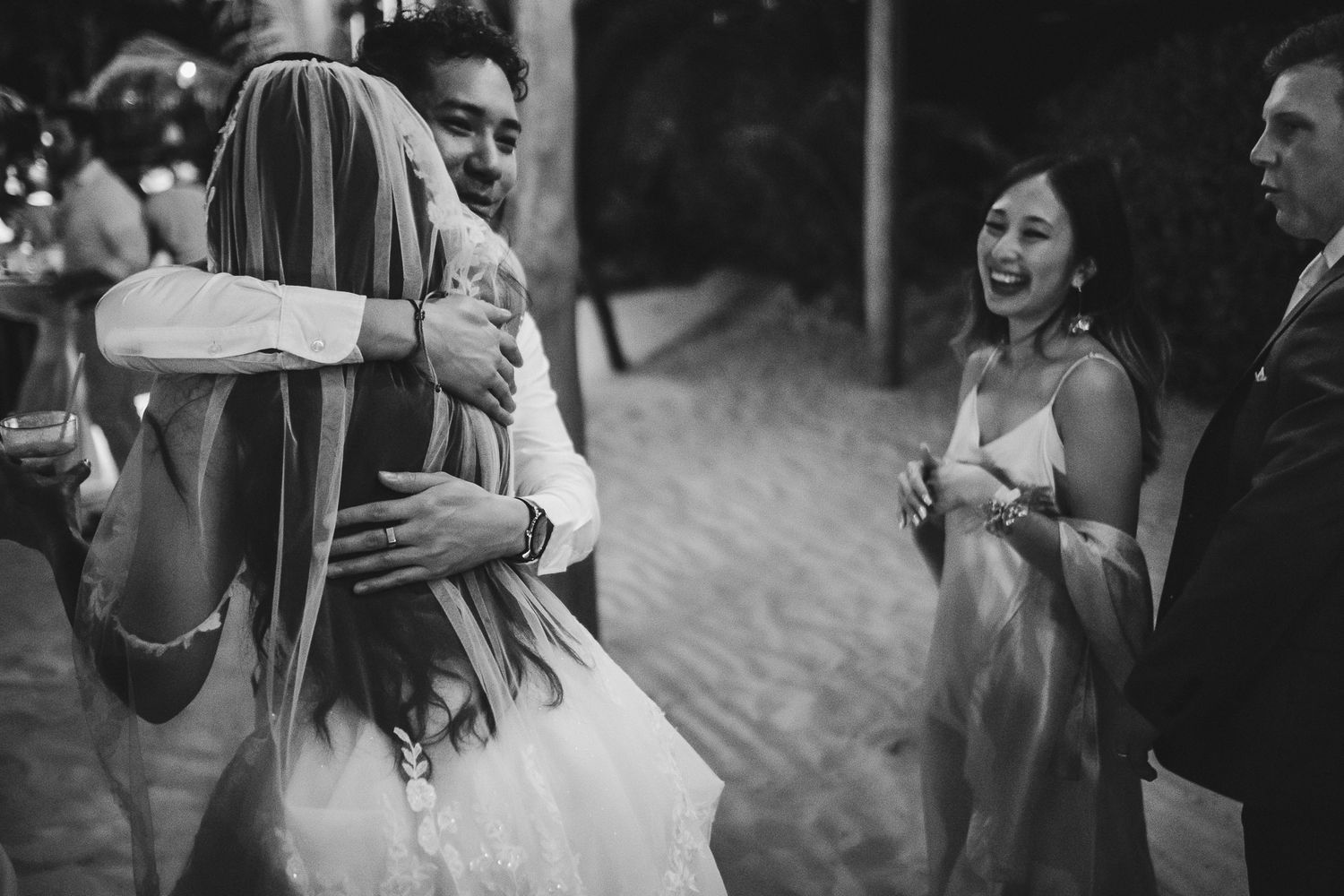 Wedding guests share a celebratory moment at an evening reception.