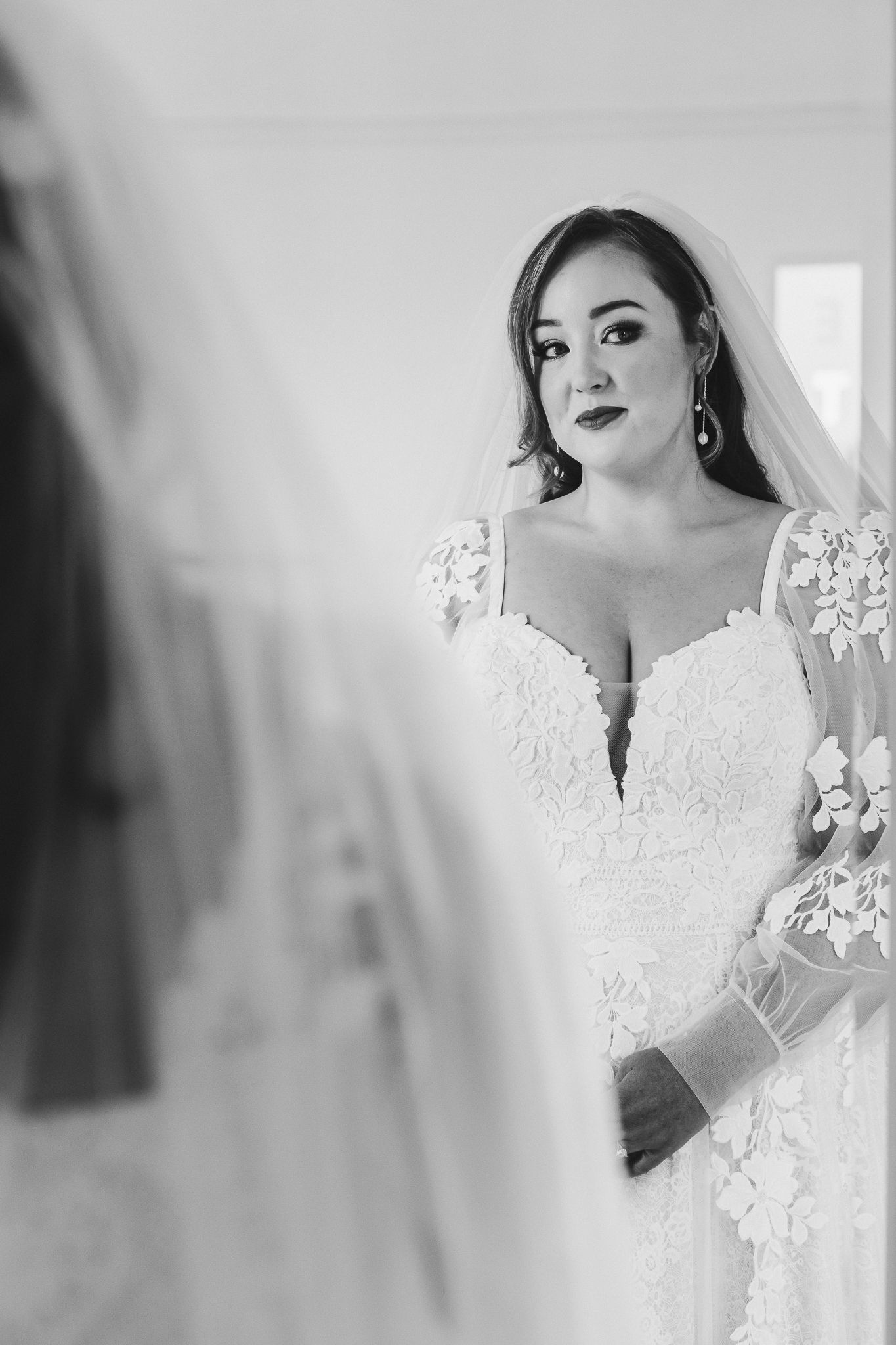 Elegant white lace wedding dress details captured in black and white photography.