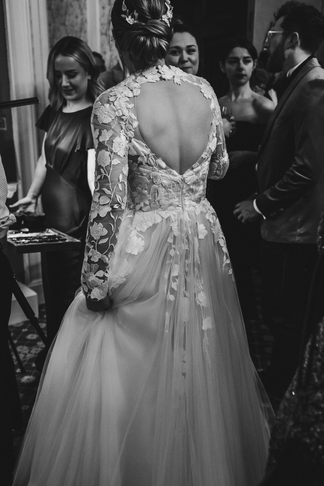 Guests sharing laughter and conversation during an elegant indoor wedding reception.