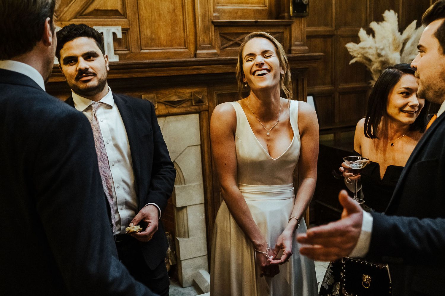 Warm wooden interior sets the scene for candid wedding reception moments.