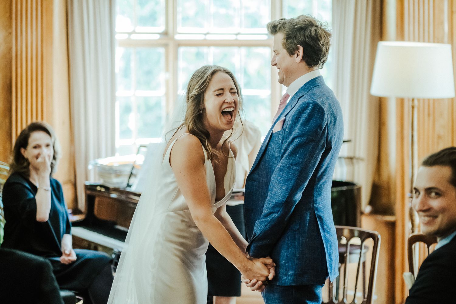Joyful moment captured during indoor wedding ceremony near a piano.
