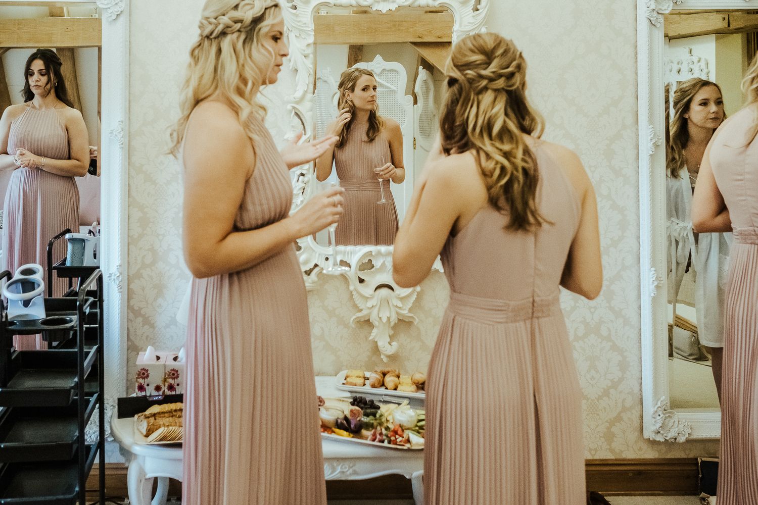 Bridesmaids in blush pink dresses prepare for the wedding celebration.