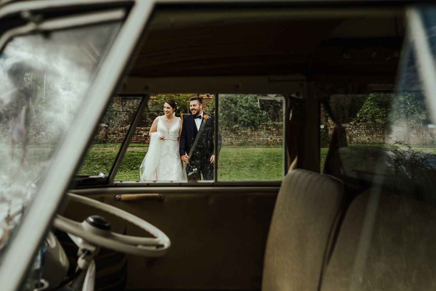Guests laugh and celebrate in a car during a wedding photo session.