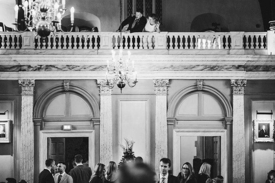 Grand ballroom interior with ornate architecture and chandeliers during an event.