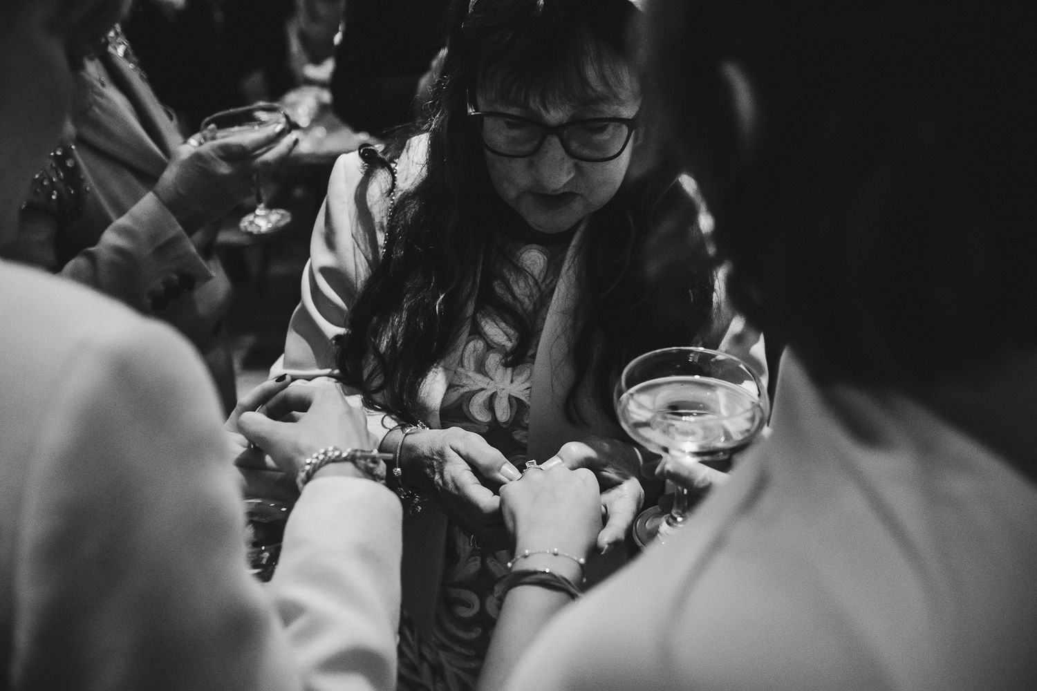Candid black and white photo of wedding celebration with guests enjoying the festivities.