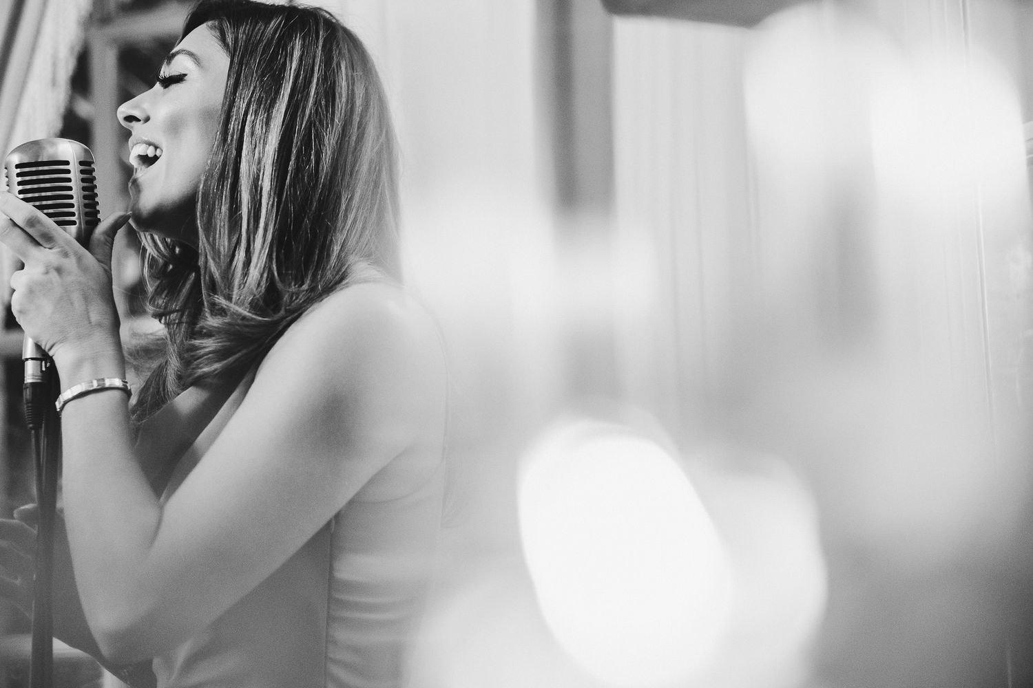 Wedding singer performs soulfully in dramatic black and white lighting.