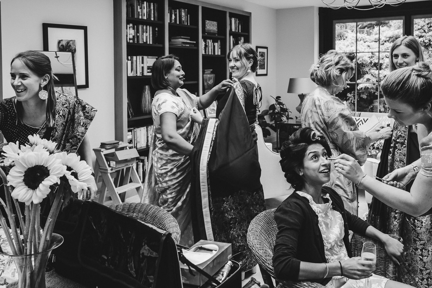 Black and white candid photo of celebration preparations with sunflowers in foreground.