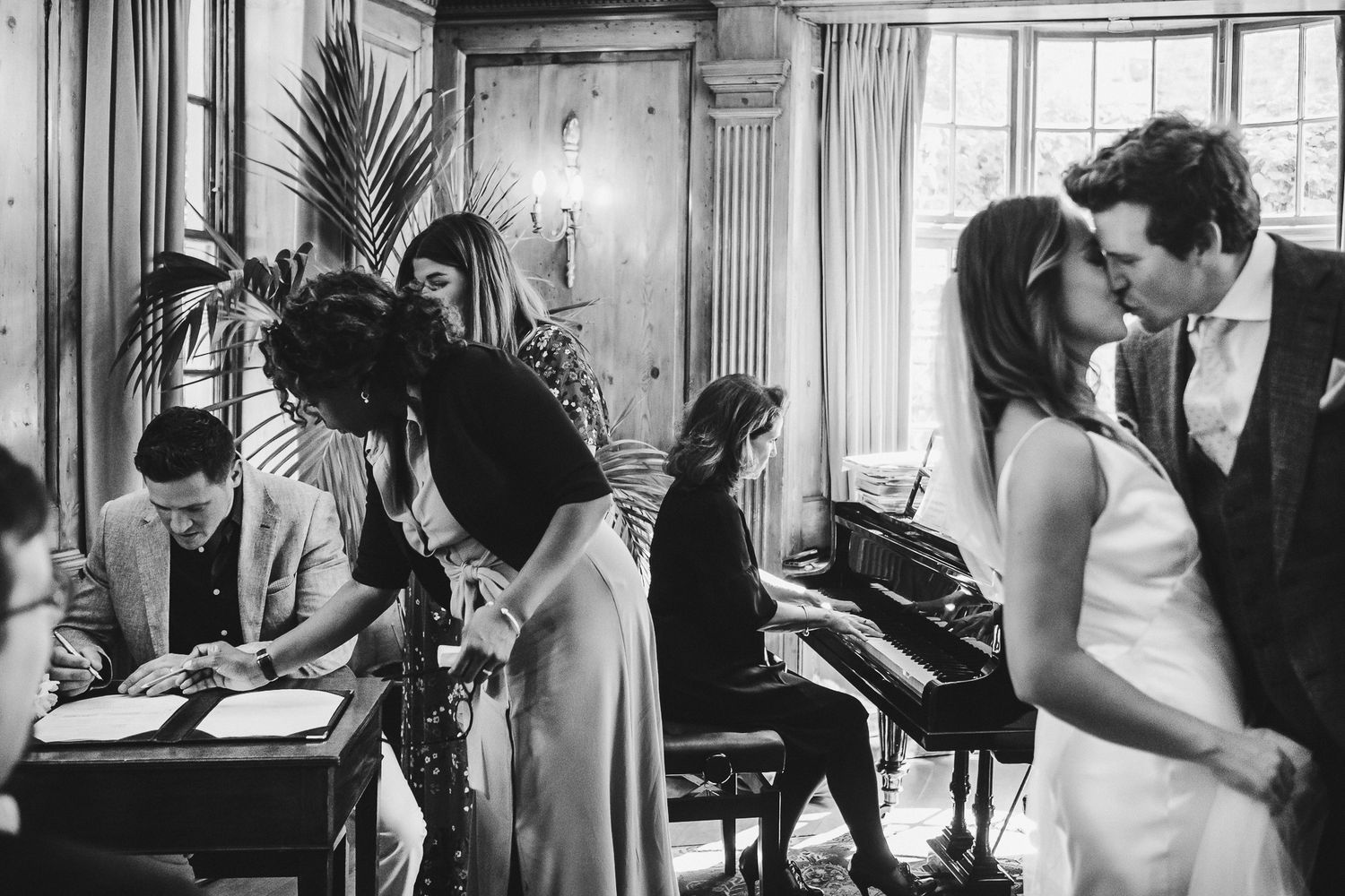 Candid black and white moments captured during an indoor wedding celebration.