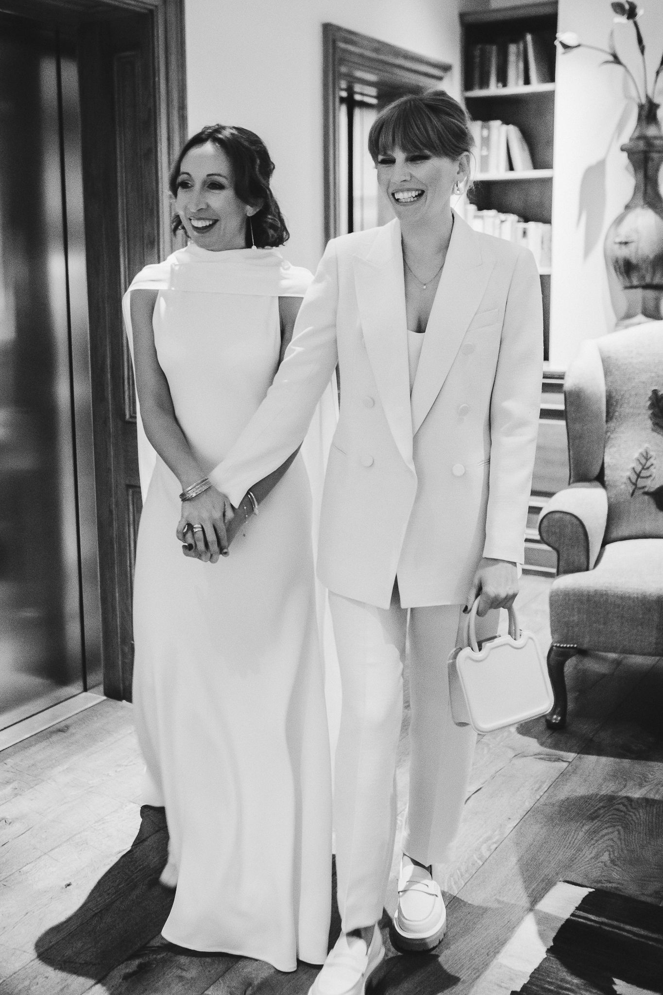 Black and white portrait of a couple in matching white wedding attire.