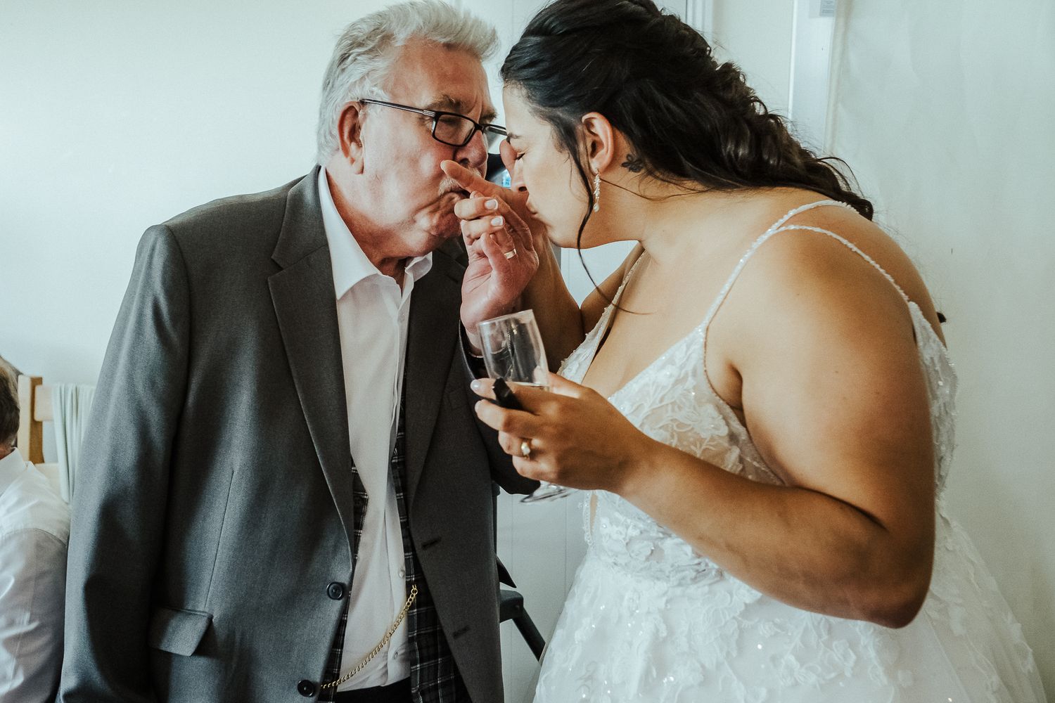 An intimate moment between guests sharing stories and drinks at an indoor wedding reception.