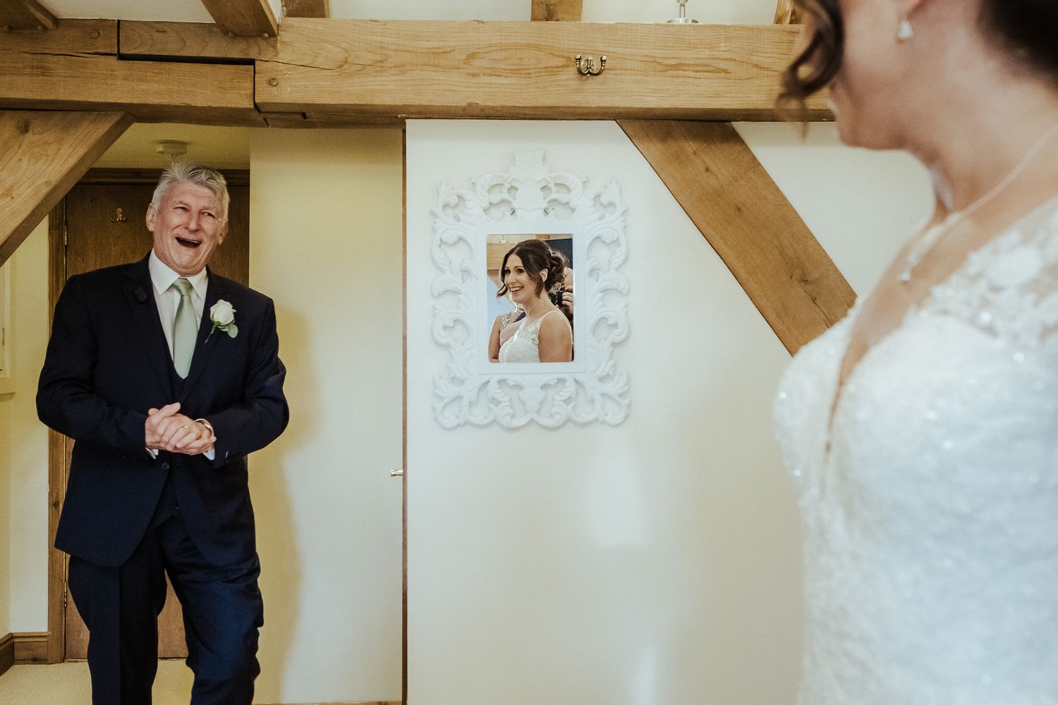 An emotional reaction captured during a wedding first look moment in a rustic wooden venue.