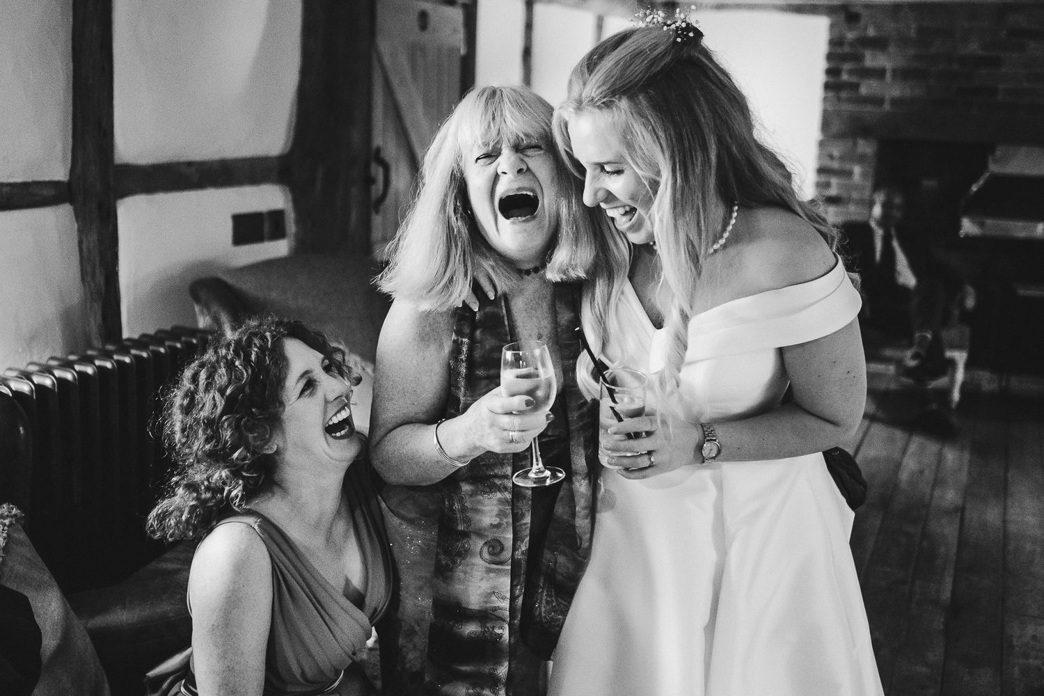 Wedding guests share candid laughing moments at the reception venue.
