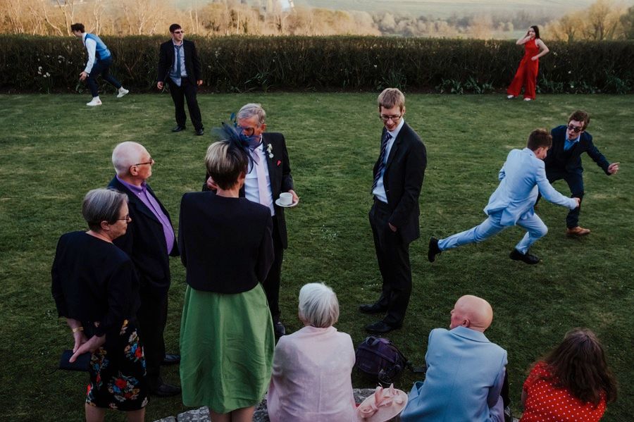 Wedding guests gathered on a lawn watching outdoor festivities.
