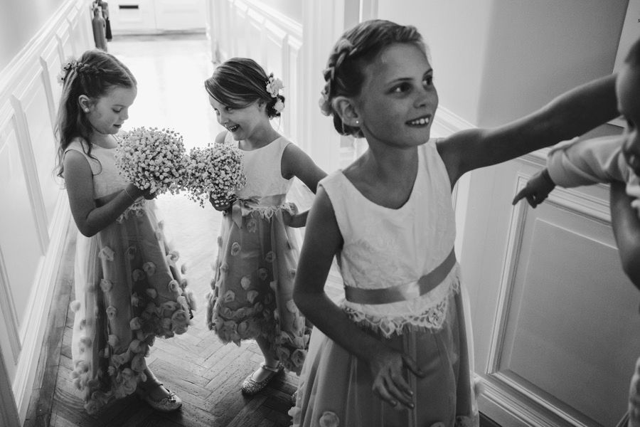 Young flower girls in matching polka dot dresses preparing for a wedding ceremony.