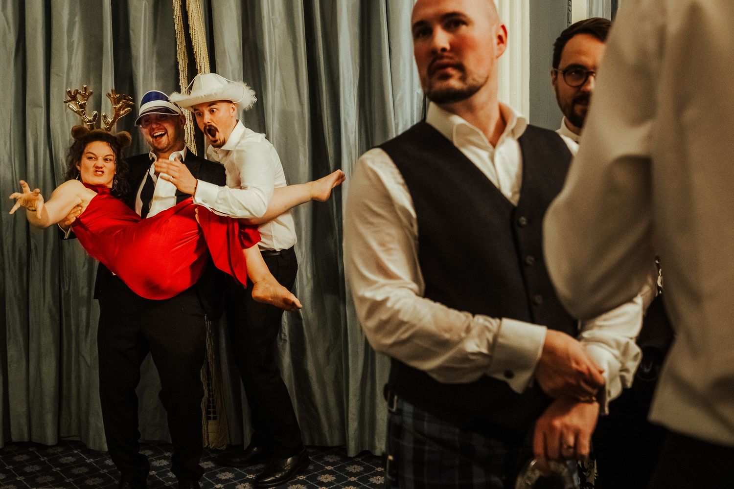 Wedding guests dancing joyfully at a dimly lit reception celebration.