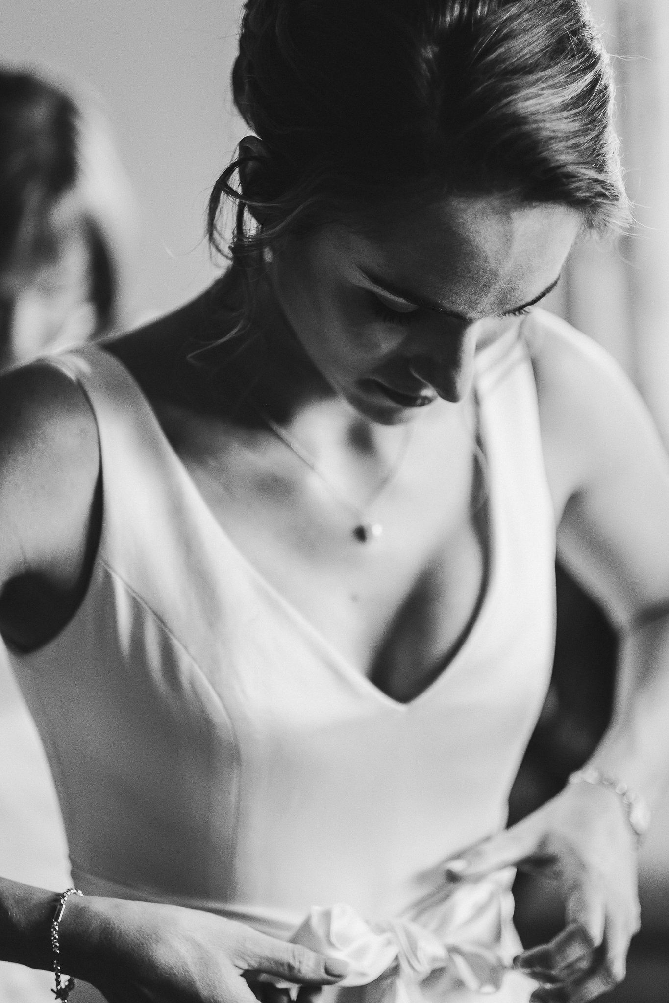 Close-up black and white portrait of bride in minimalist V-neck wedding dress.