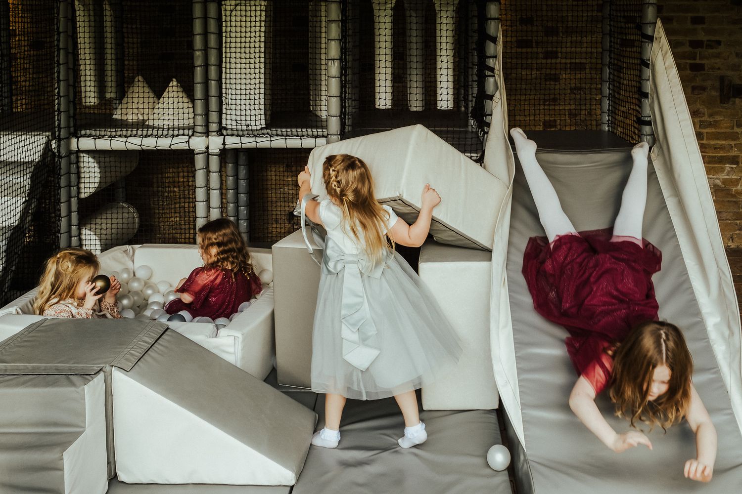 Playful scene on white steps with flowing dresses and dynamic poses.