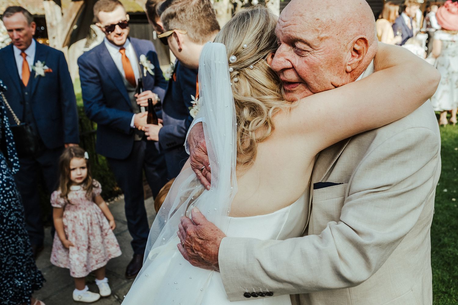 Emotional hugs and embraces shared between wedding guests during outdoor reception.