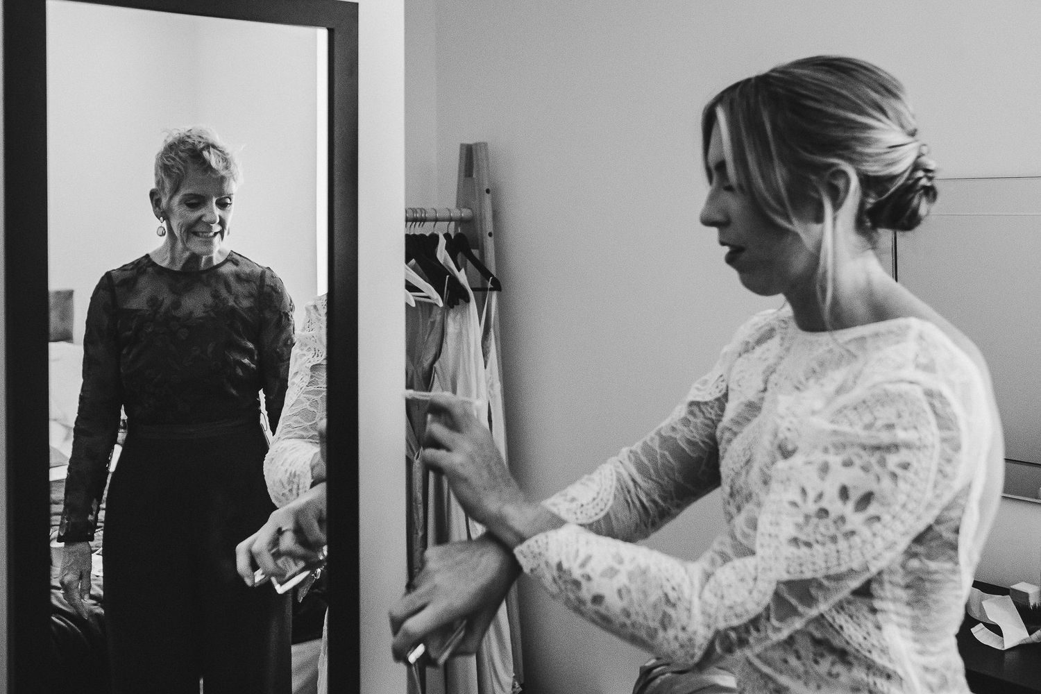 Black and white photographs showing final wedding dress adjustments and preparations.