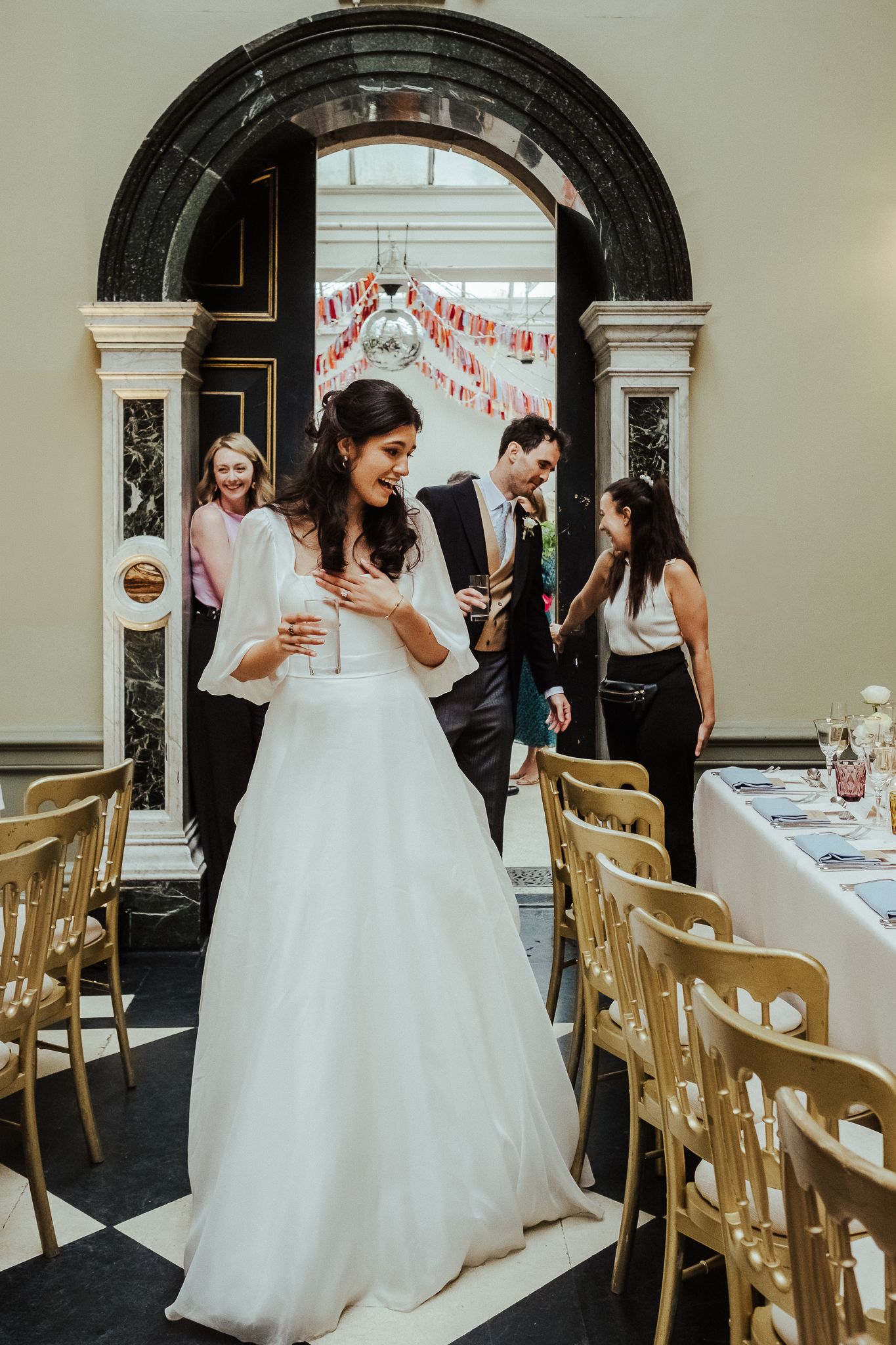Elegant wedding reception venue with white chairs and arched doorways.