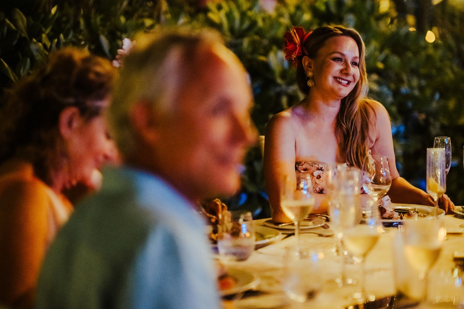 Candid moment of guests enjoying a celebratory dinner at an outdoor wedding reception.