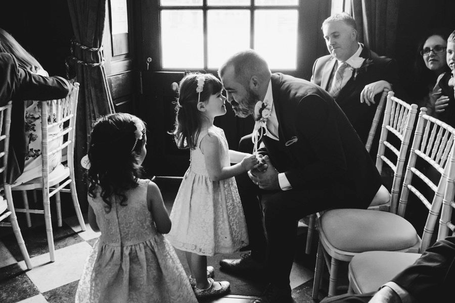 A sweet moment between young flower girls and an elder guest at a formal wedding.