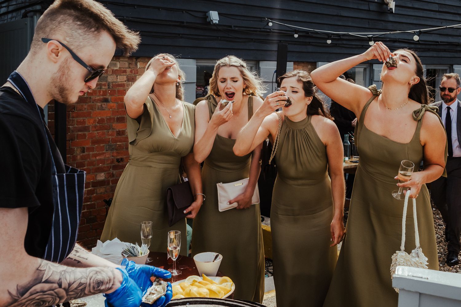 Guest wearing stylish sunglasses and halter top enjoys sunny outdoor wedding celebration.