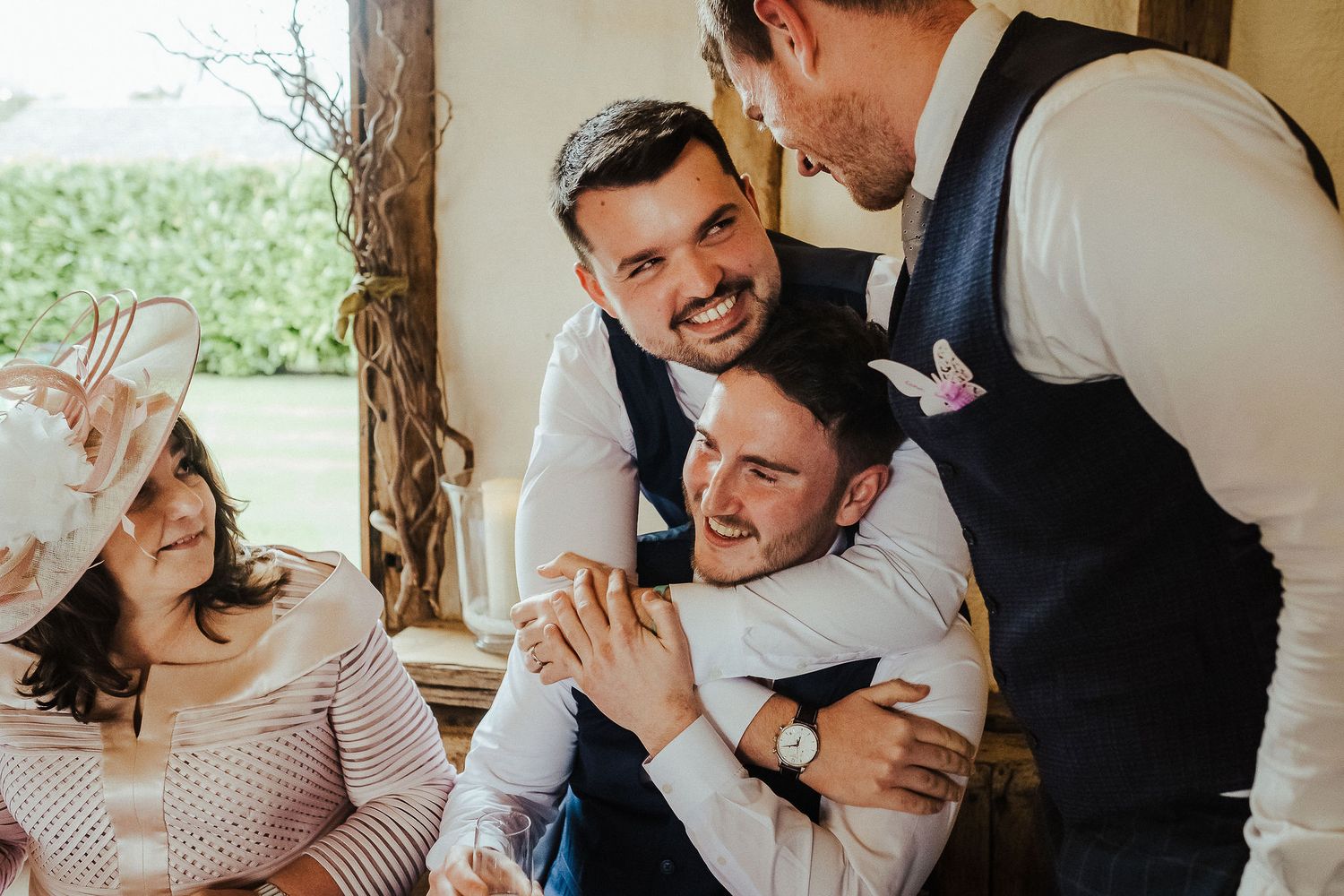 Candid moment of wedding guests laughing together during reception.