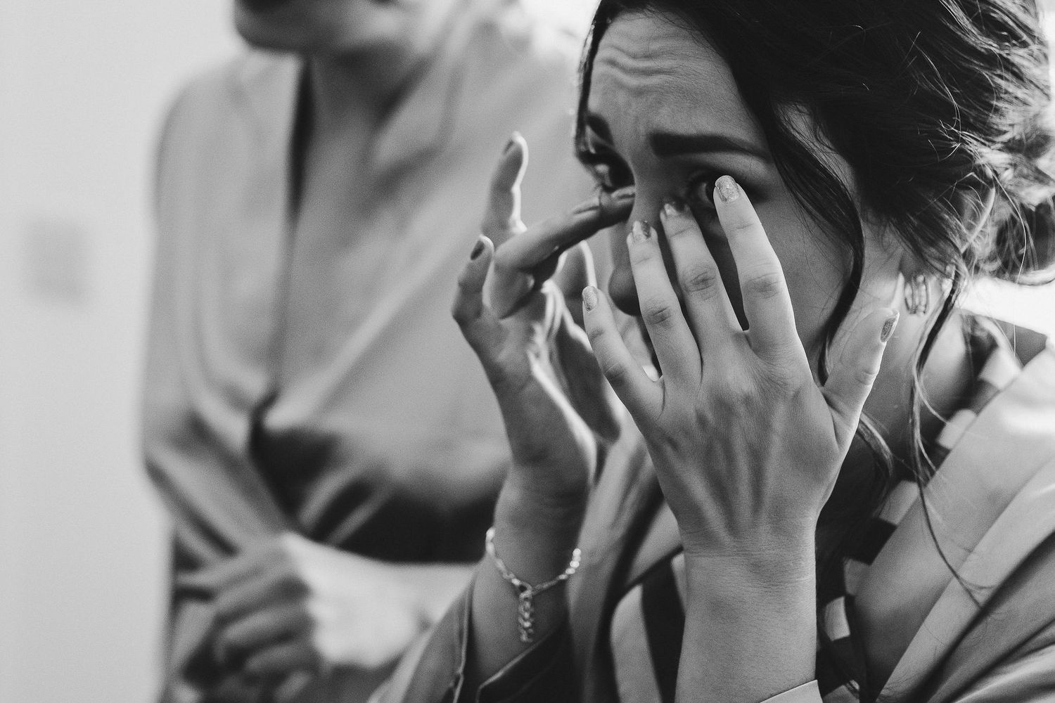 An emotional black and white moment captured during wedding preparations.