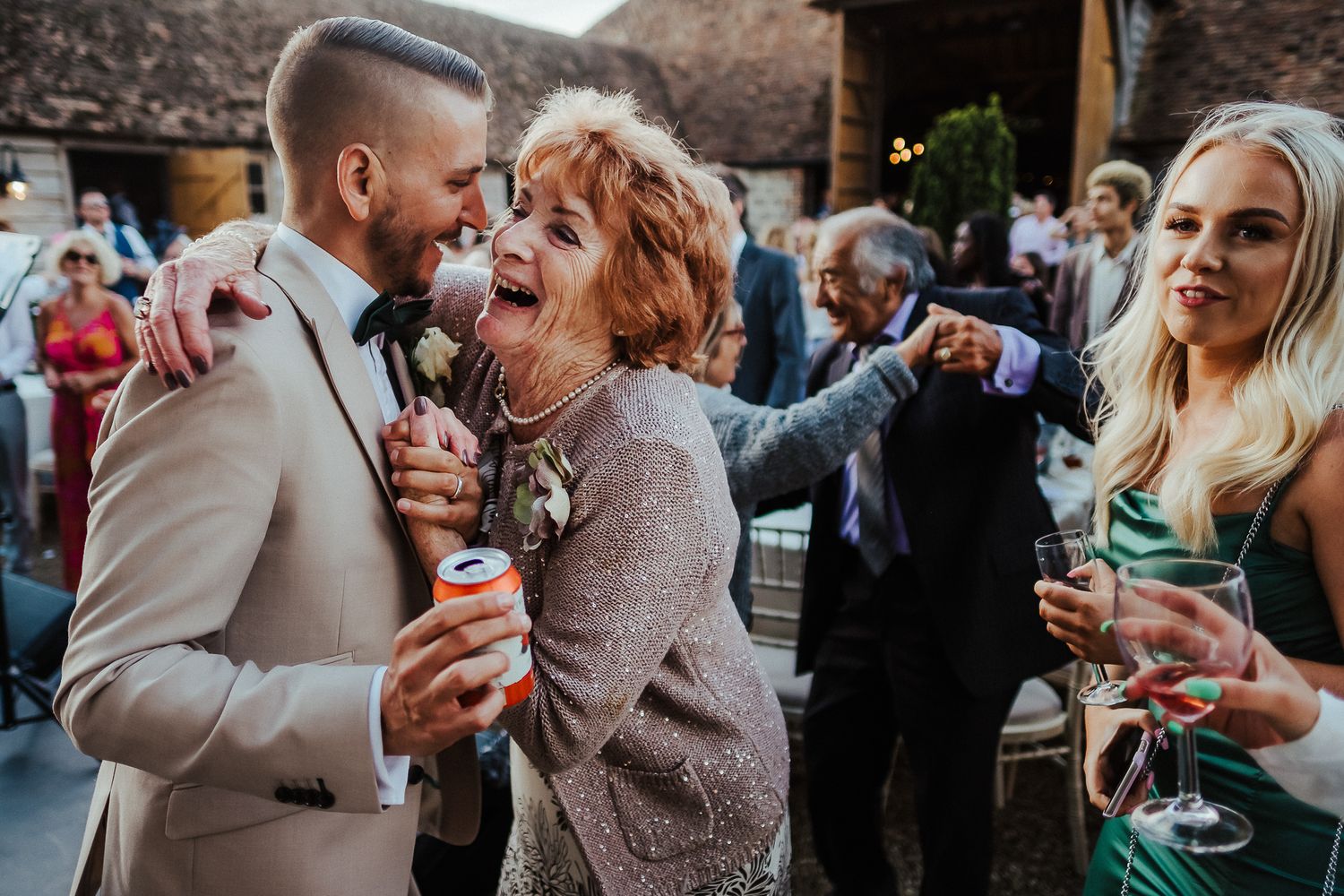 Wedding guests sharing laughter and joyful moments during evening reception festivities.