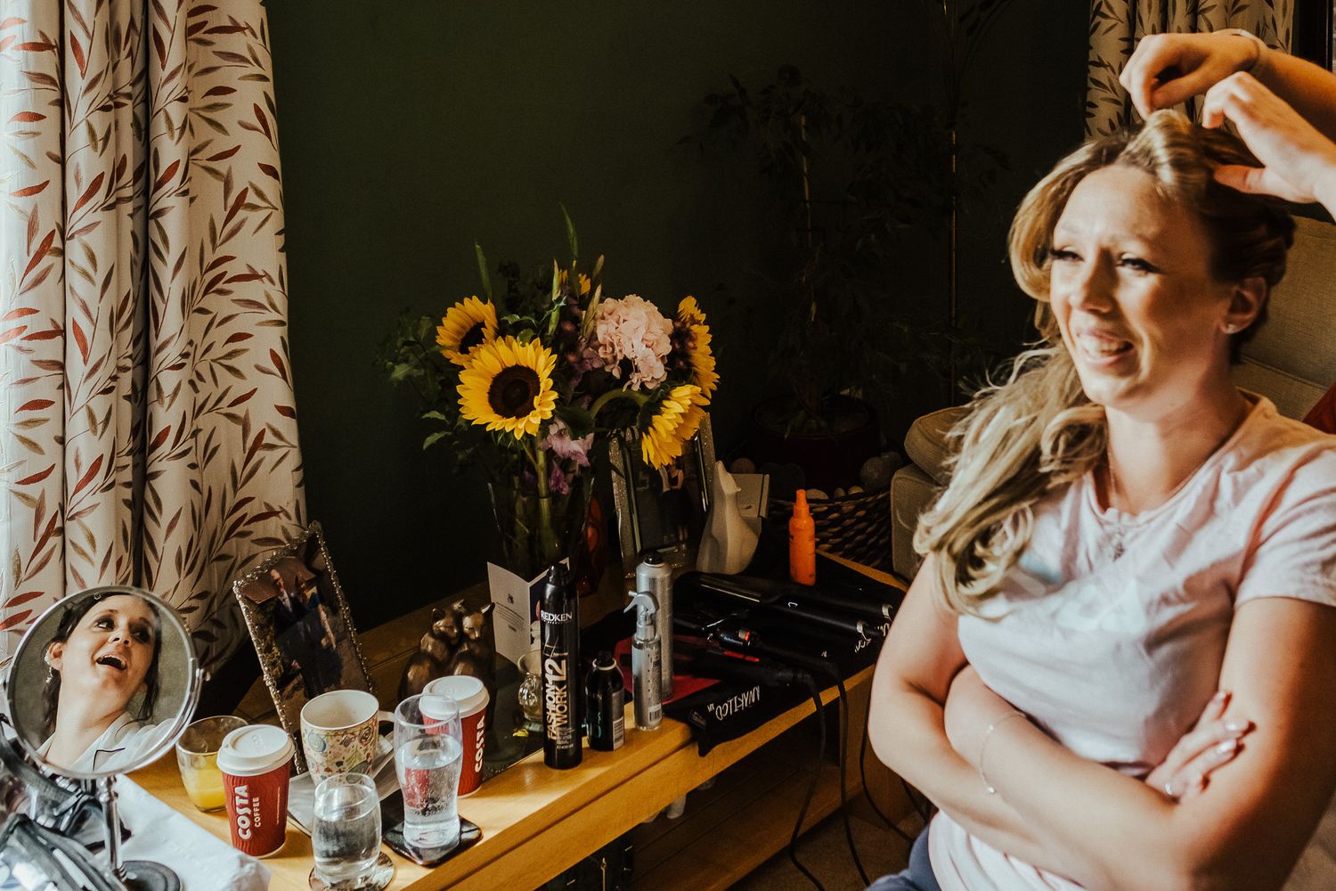 A morning preparation scene with sunflowers and makeup supplies on a wooden table.