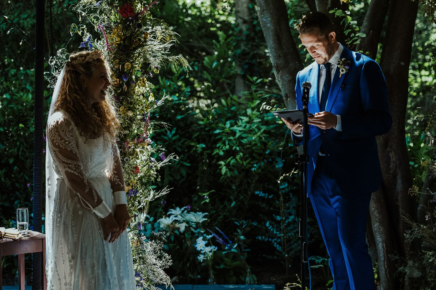 Couple performing a magical confetti toss moment during outdoor wedding ceremony.