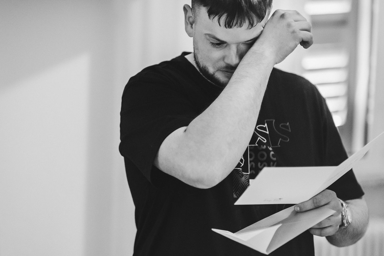 Black and white portrait of someone reading a document intensely.