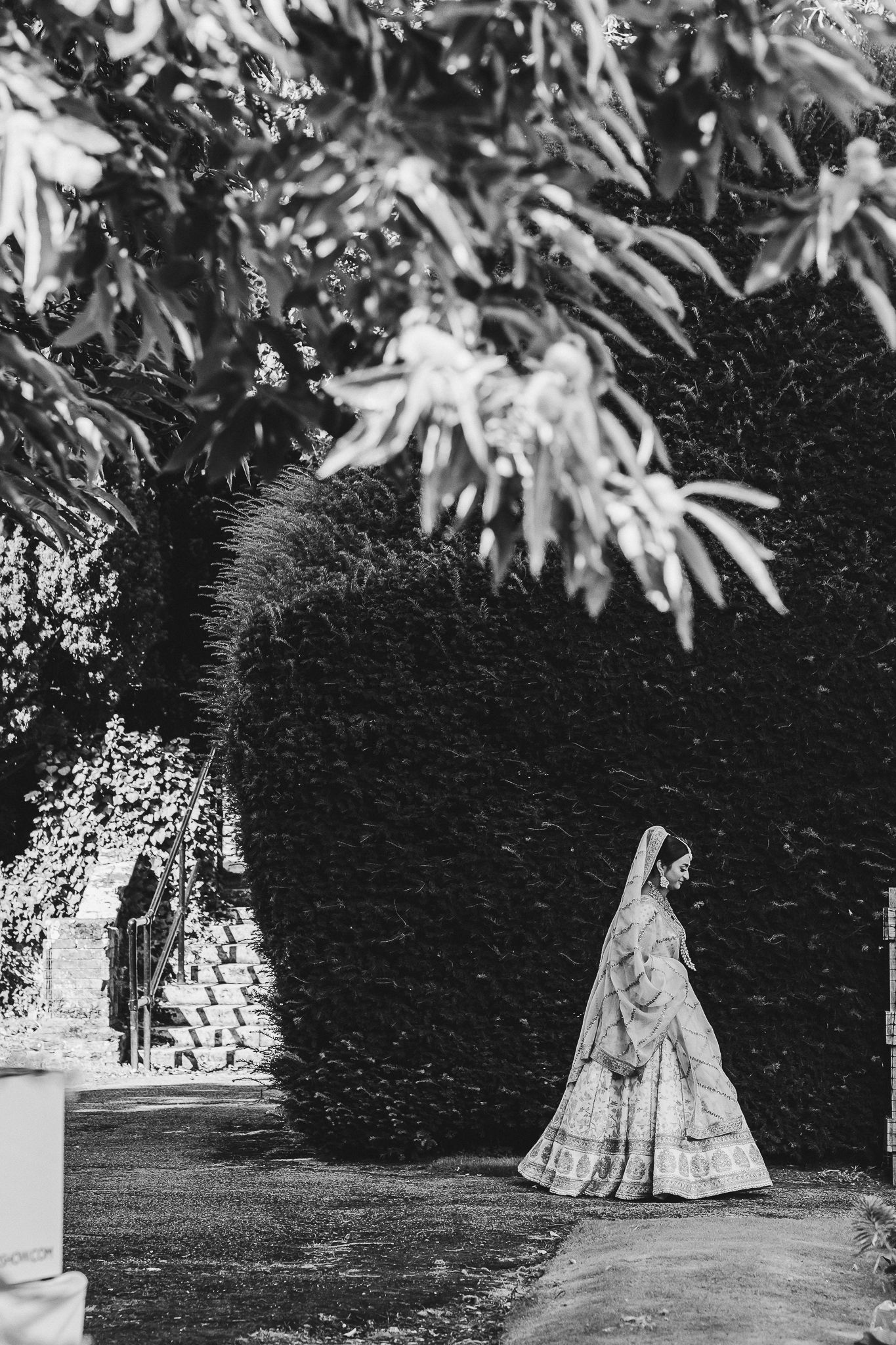 A sequence of vintage photographs showing figures walking along a tree-lined garden path in Victorian-era dresses.