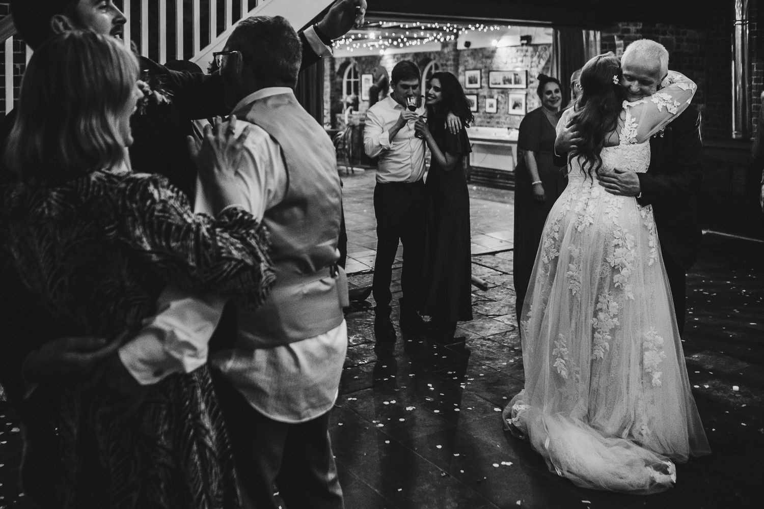 A black and white shot of couples dancing during an outdoor wedding reception.