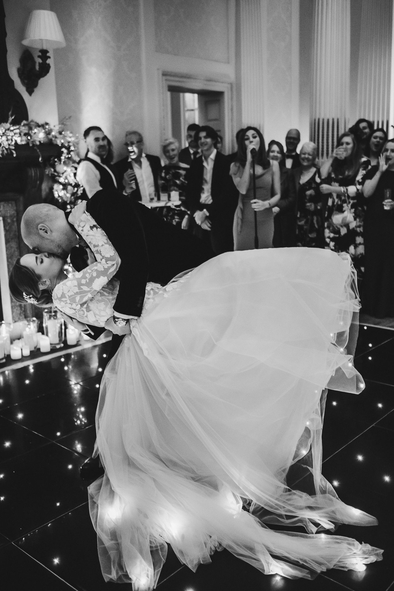 Dramatic dance sequence captured in black and white during wedding reception.