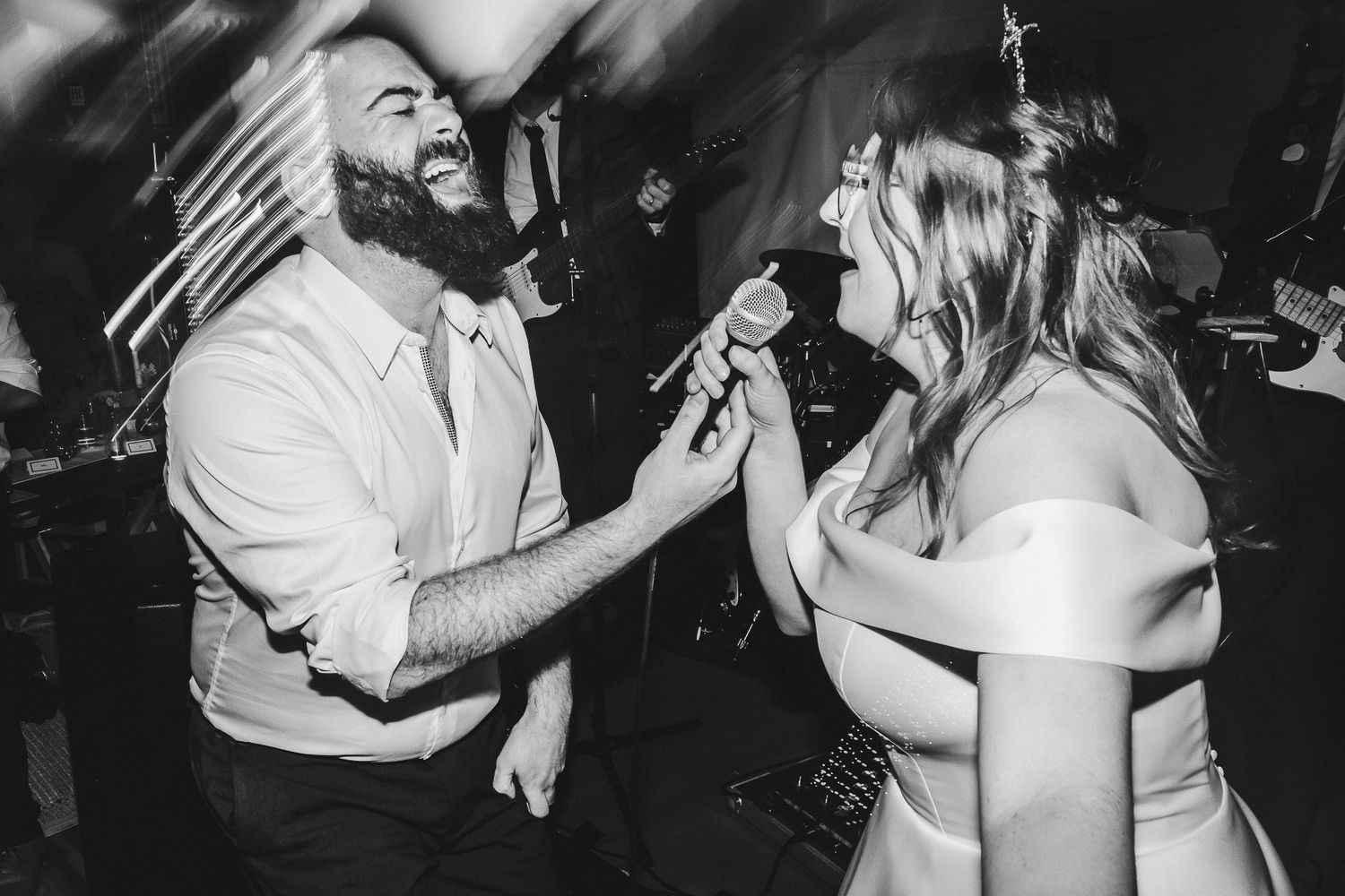 High-energy wedding reception dance floor moment captured in black and white.