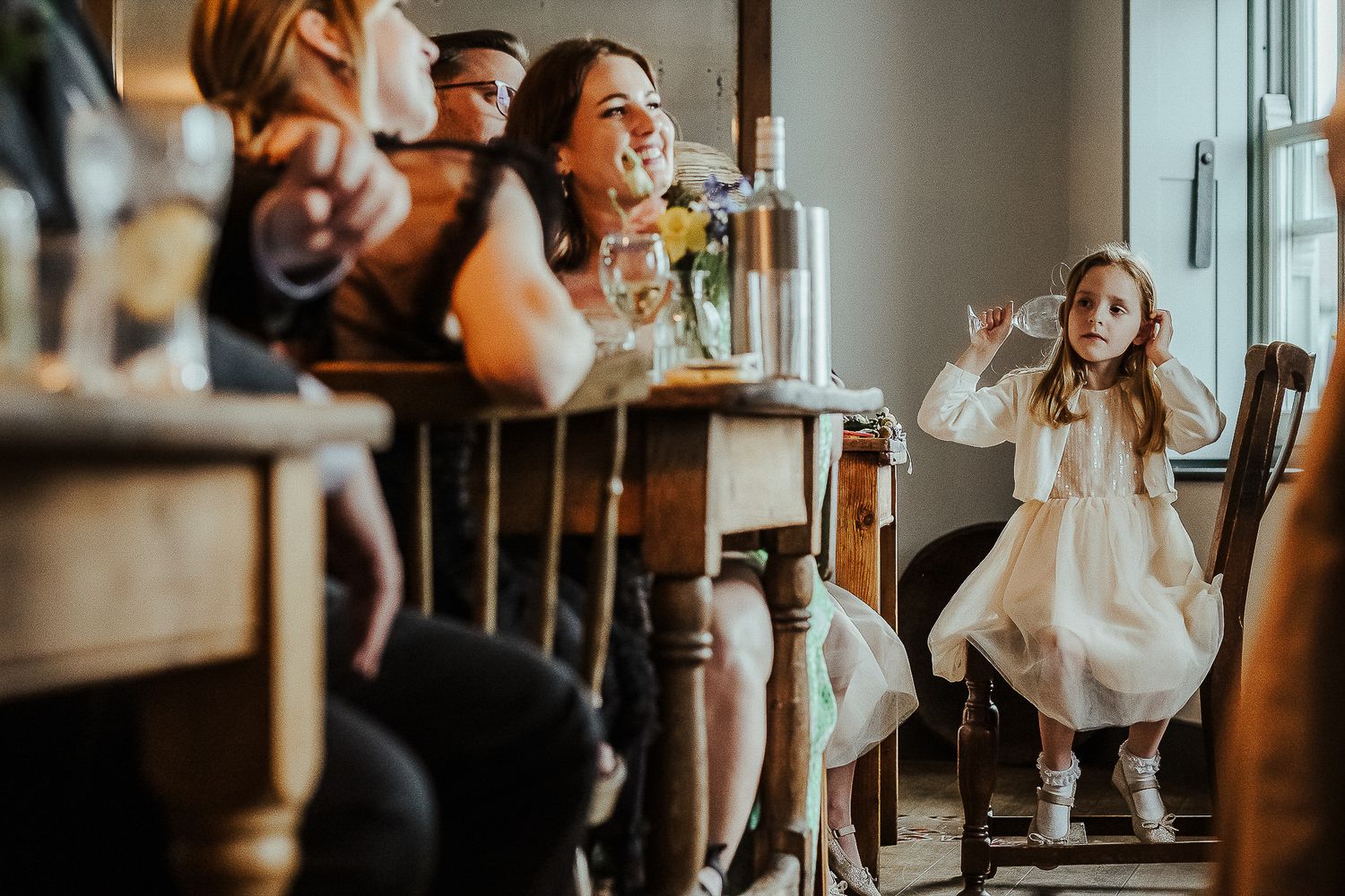 Young guest in white dress enjoying refreshments at an elegant wedding reception.