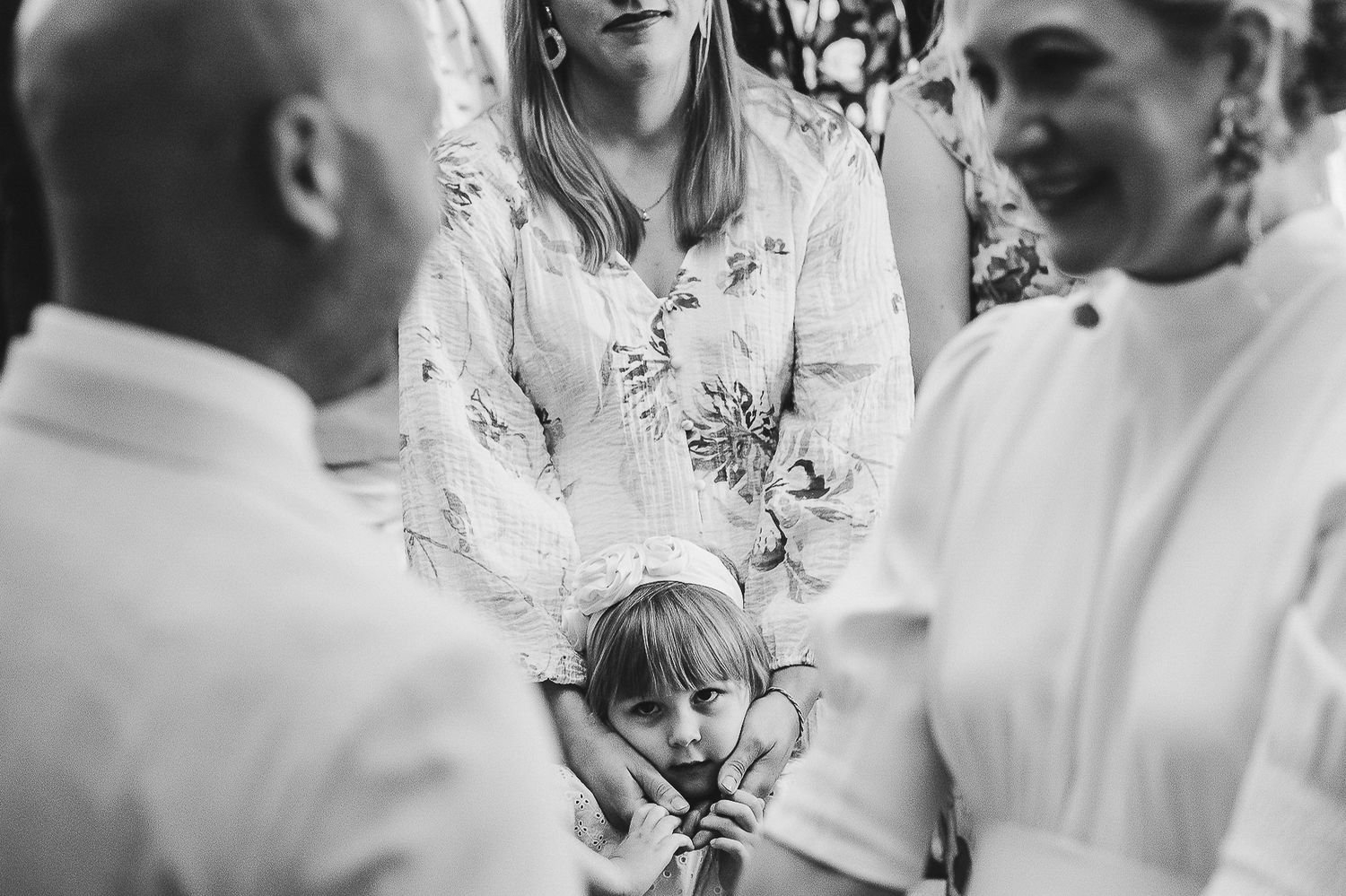 A candid black and white moment captured during a wedding ceremony showing emotional reactions.