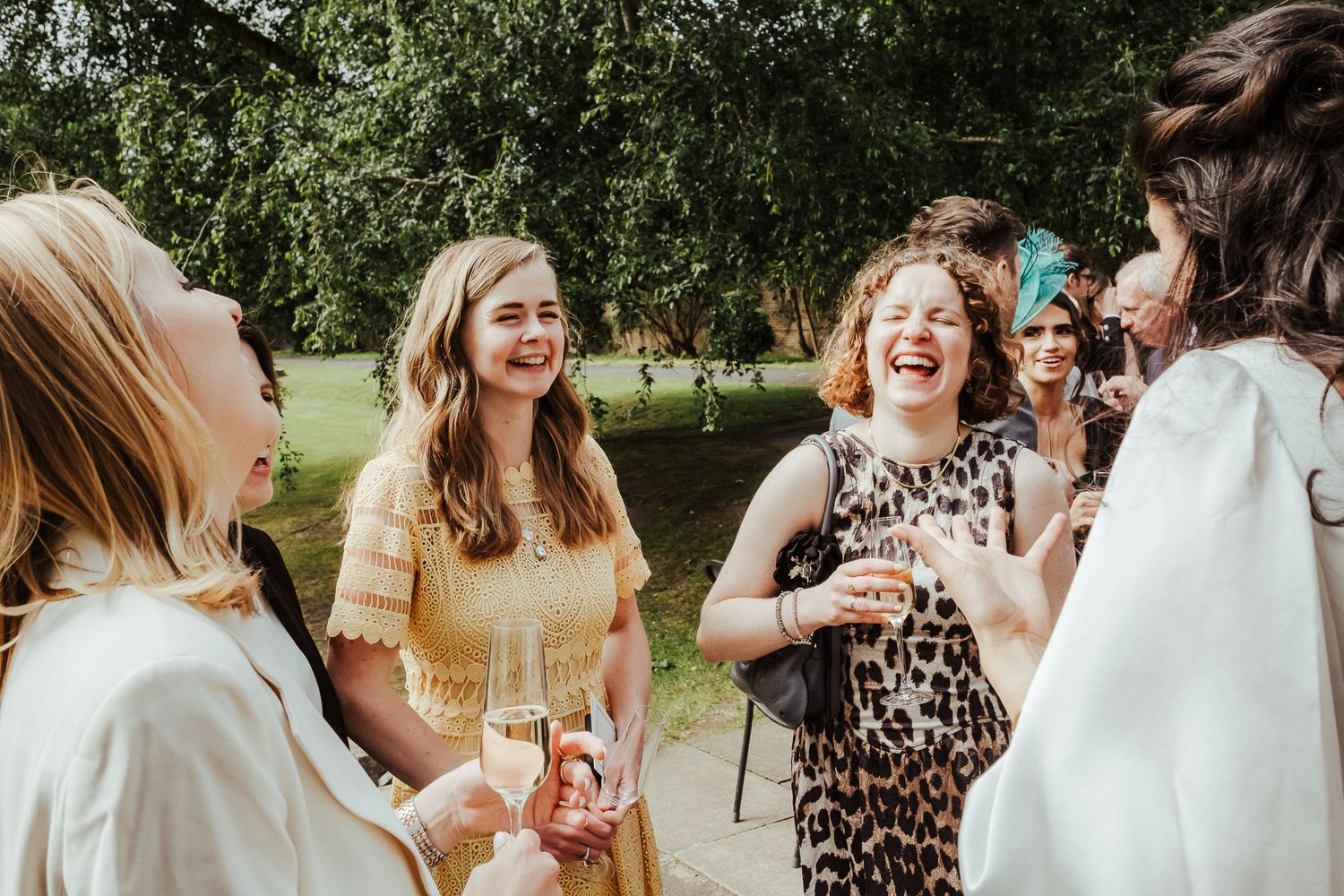 Elegant outdoor wedding reception with guests mingling in summer garden.