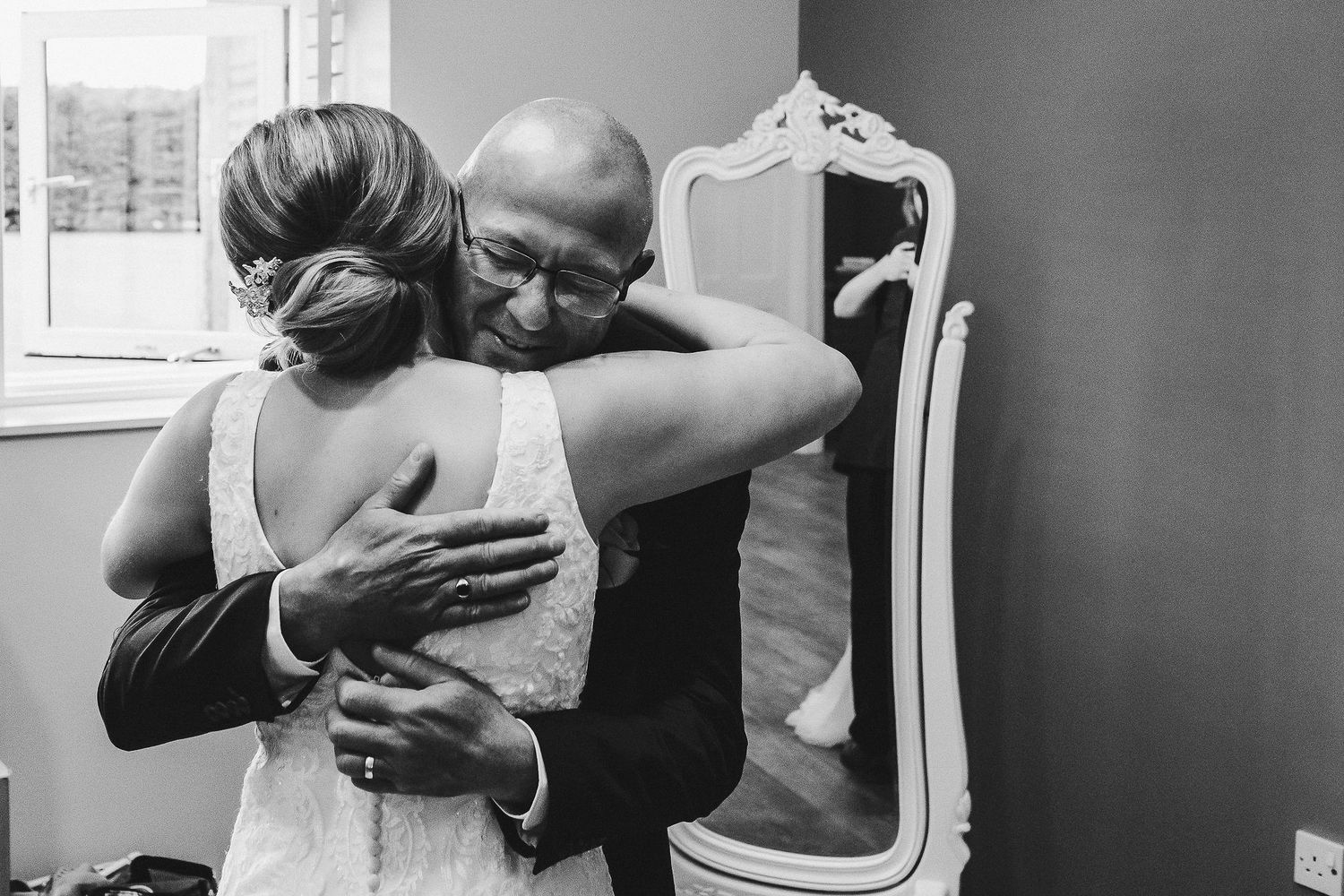 Emotional black and white moment of an embrace on wedding day.