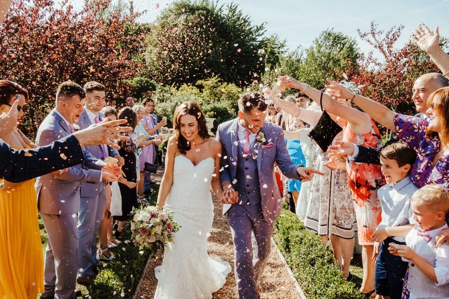 A celebratory wedding party with guests enjoying an outdoor garden setting.