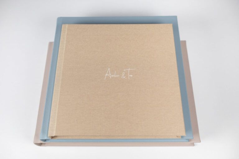 Wedding album with minimal design in beige linen cover and blue protective case.