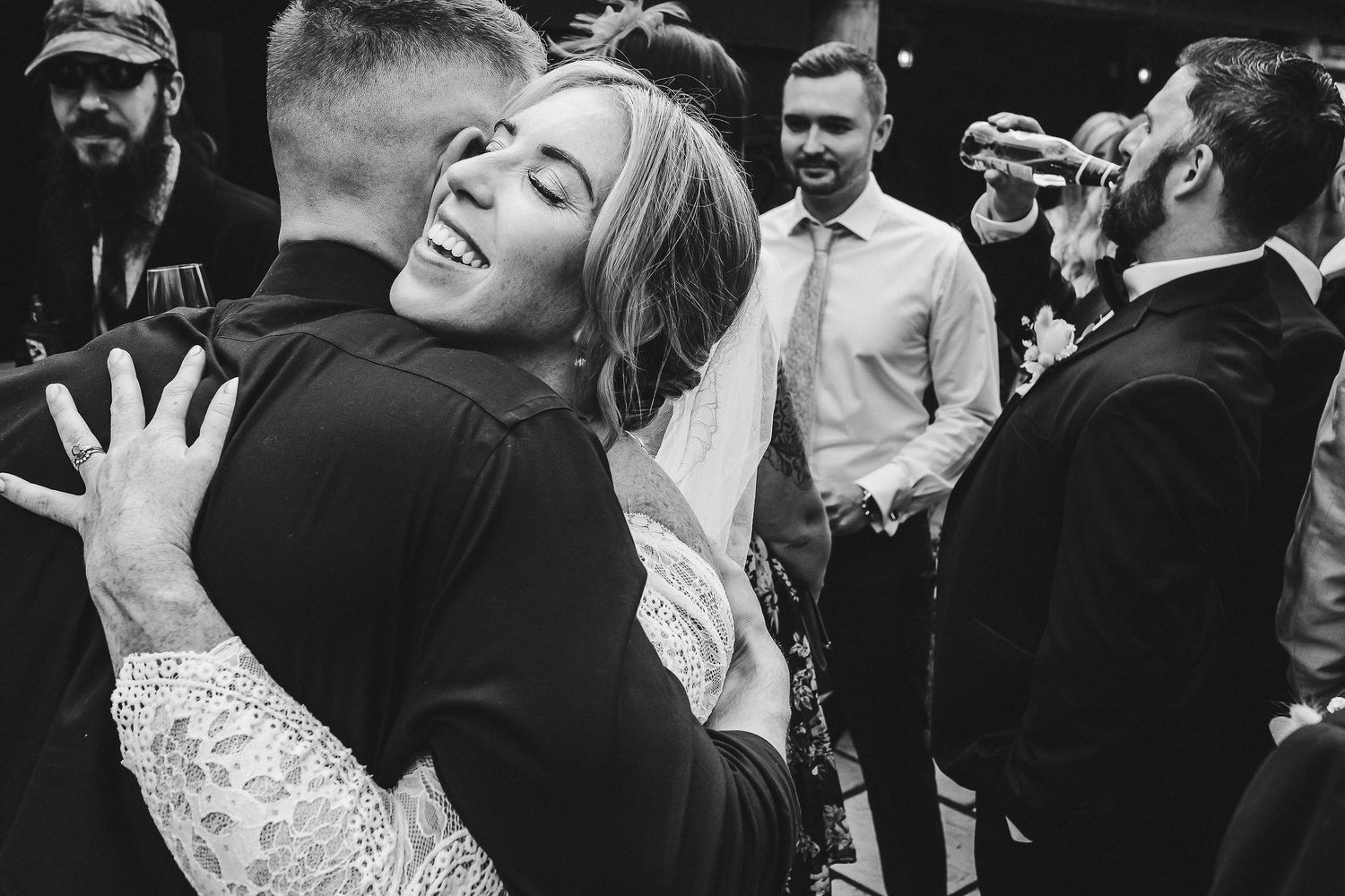 A black and white capture of a joyous embrace during wedding celebrations.