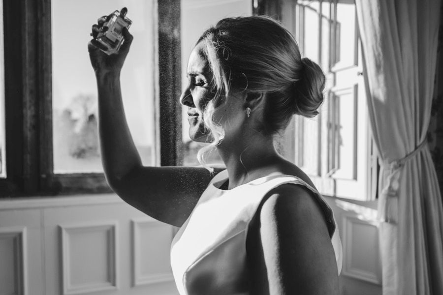 Black and white photo showing interior of elegant wedding venue with natural lighting.