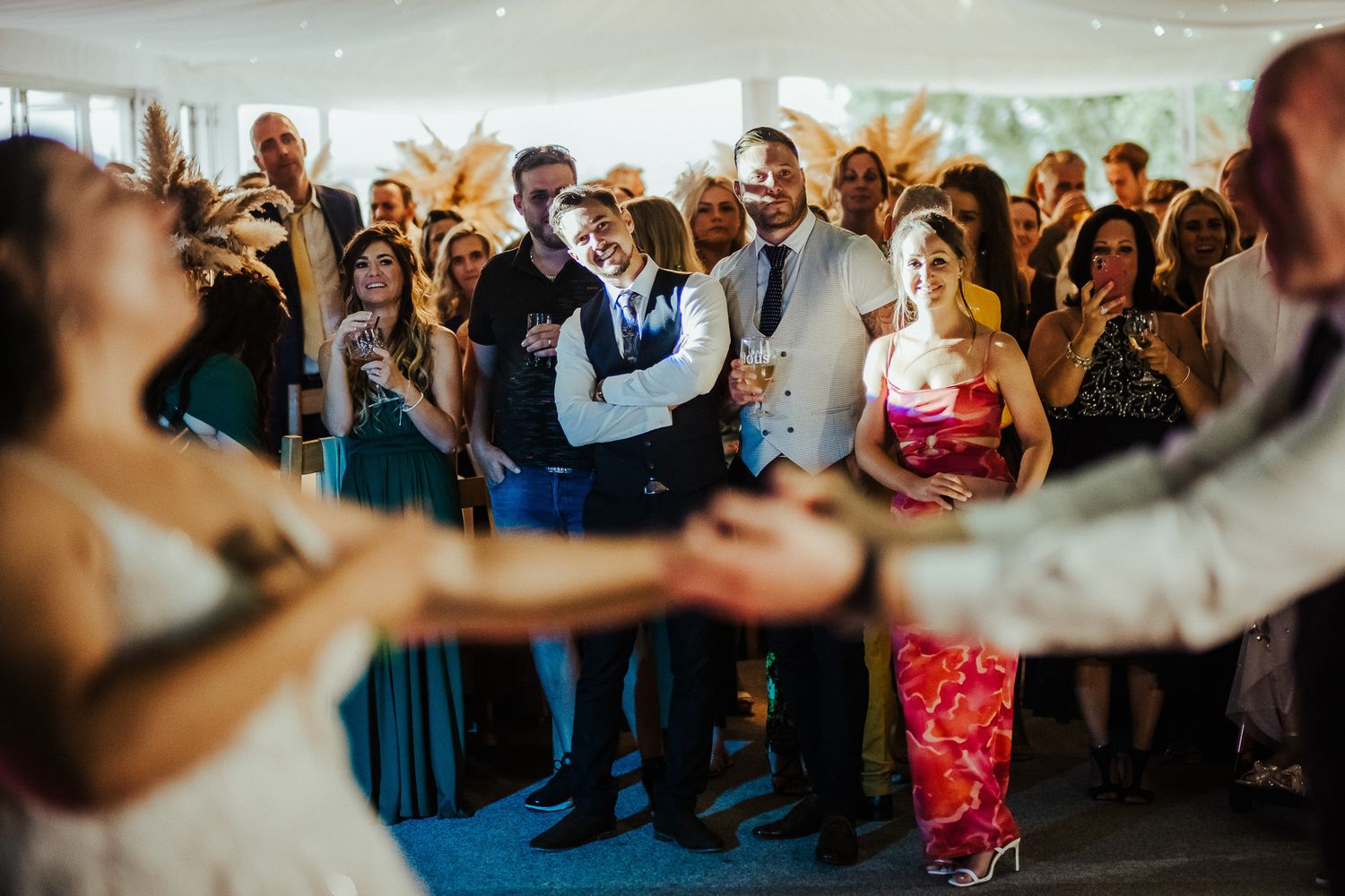 Wedding guests gather in a circle watching a couple dance at their reception.