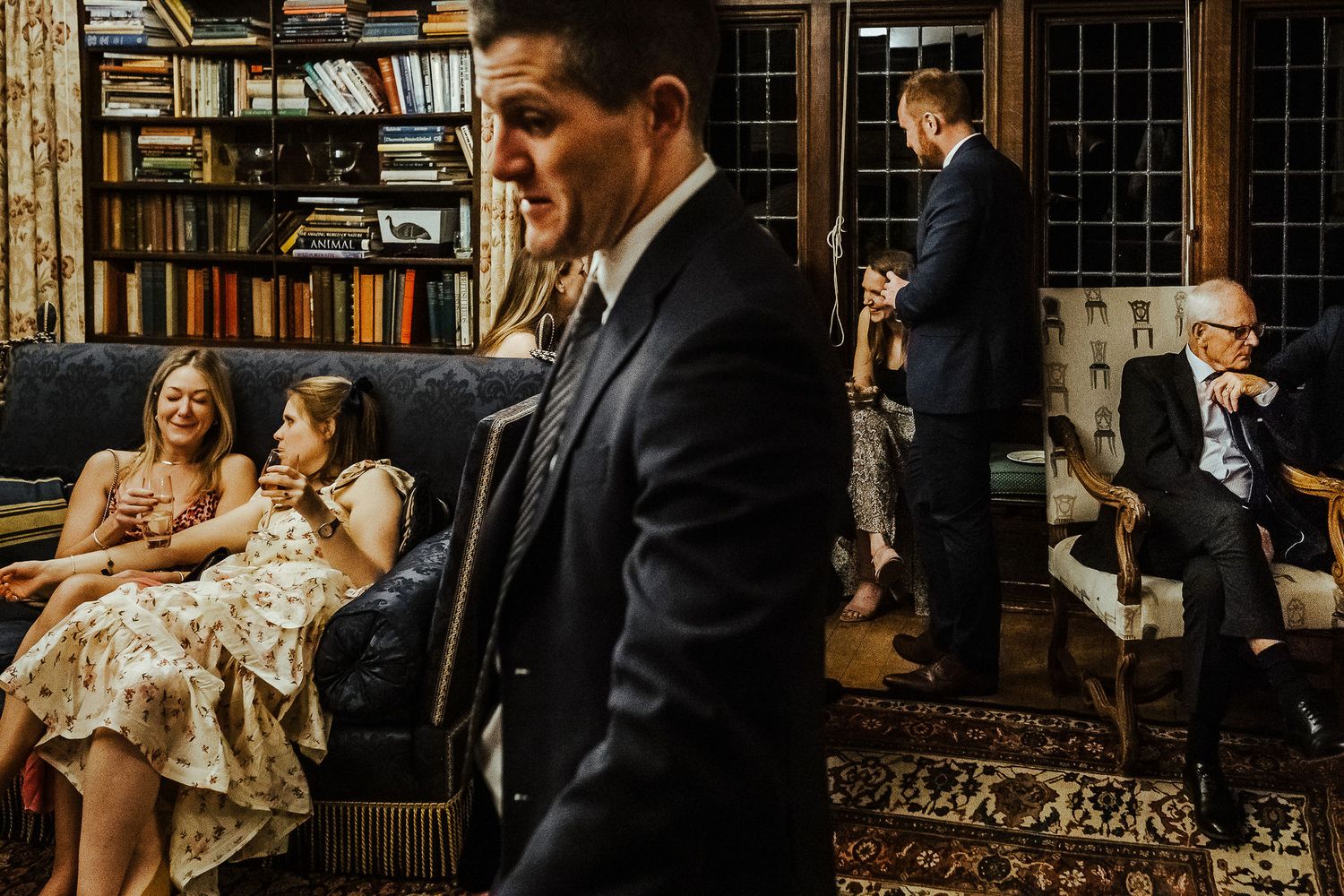 Formal gathering in a library setting with guests in evening attire.
