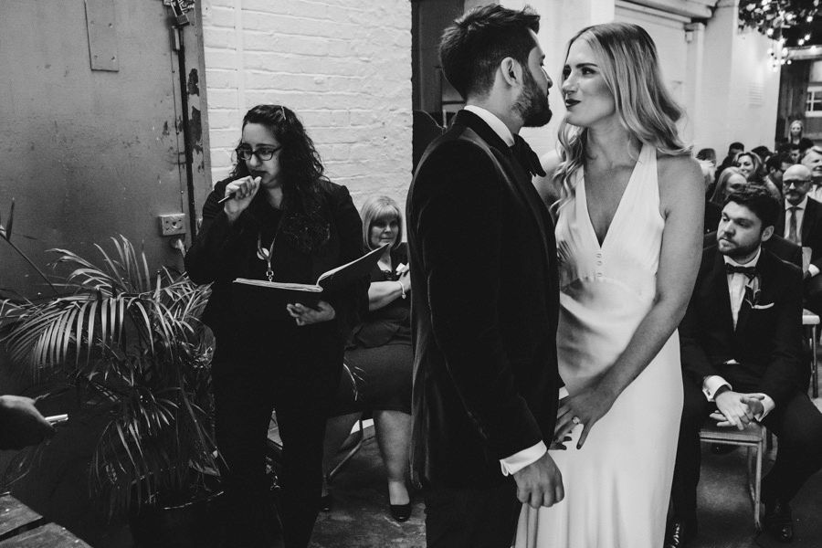 Candid moments between wedding guests at an elegant white venue.