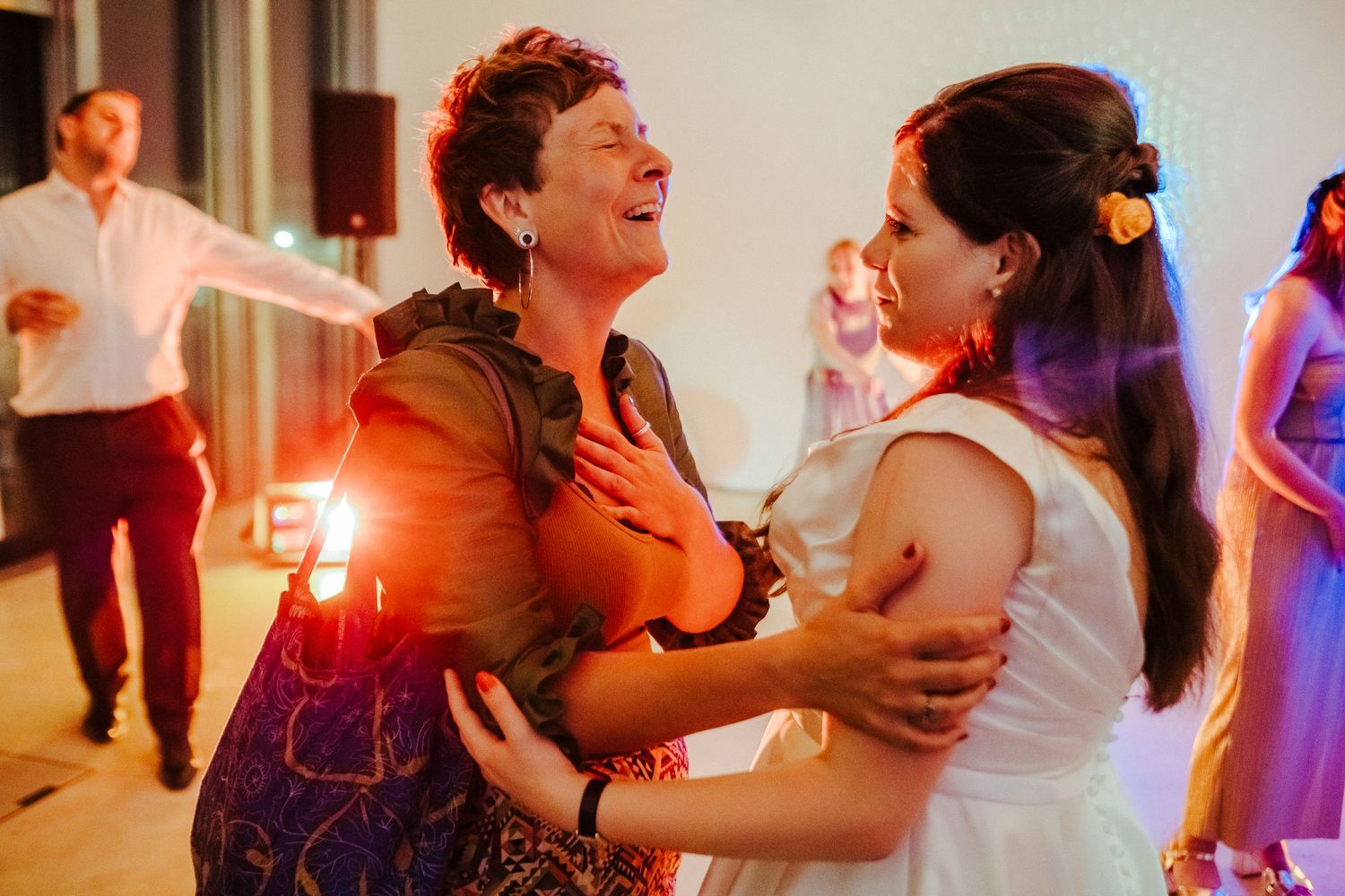 Two partygoers share an enthusiastic dance moment under warm lighting.
