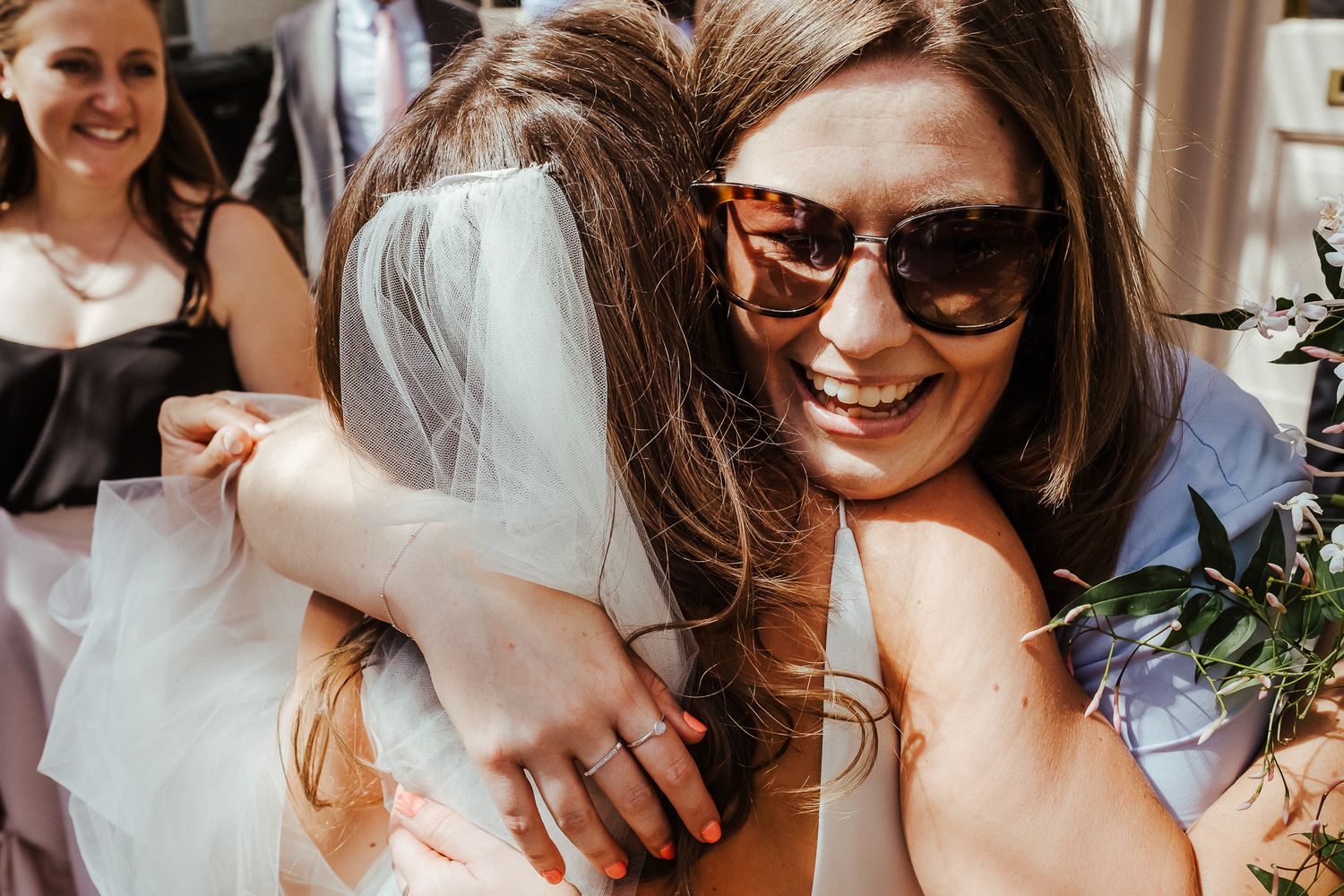 Wedding guests sharing candid laughs and smiles during outdoor festivities.